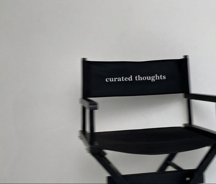Black director's chair with 'curated thoughts' text on a white background